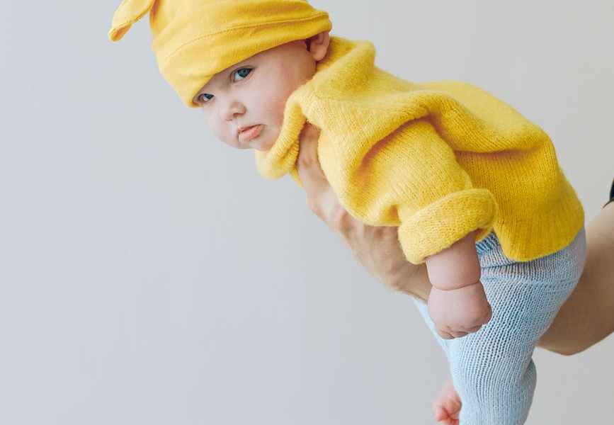 child in yellow knit cap and yellow sweater